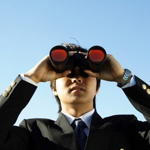 Businessman looking through binoculars, can be used for vision/prospects metaphor